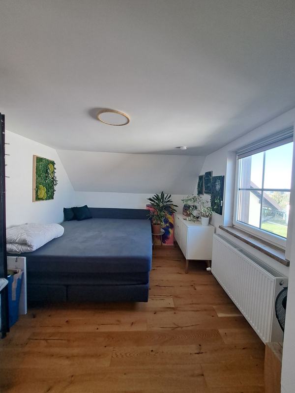 Zimmer mit Bett und großem Fenster